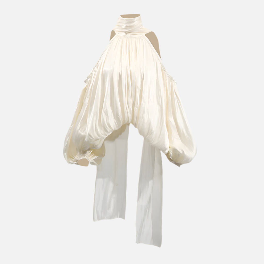 Blusa Matilda bege com gola laço, ombros vazados e mangas bufantes. Romântica, fluida e elegante para ocasiões especiais.

