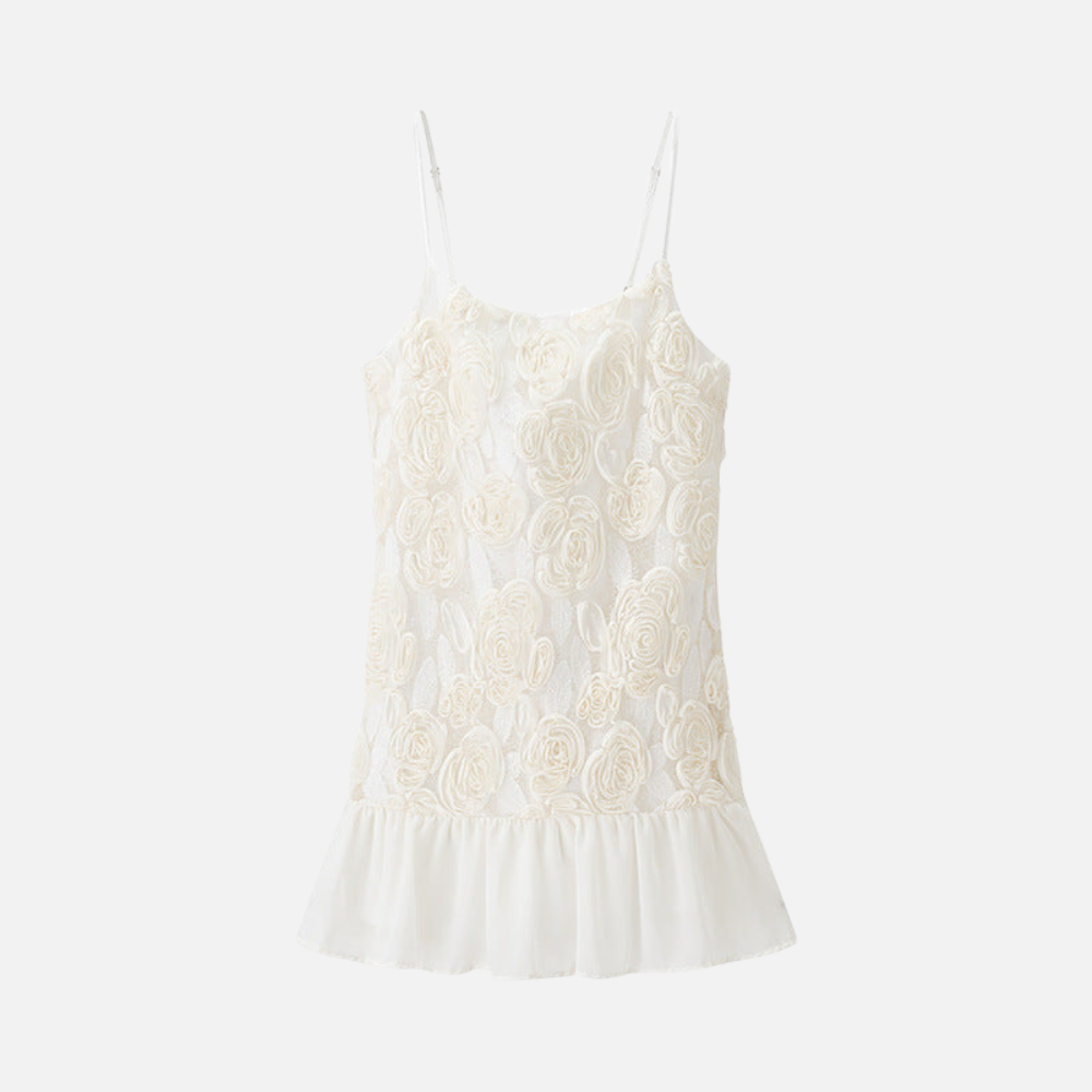 Vestido branco Maceió com aplicações florais, alças finas e babado plissado. Look leve, romântico e sofisticado para o verão.

